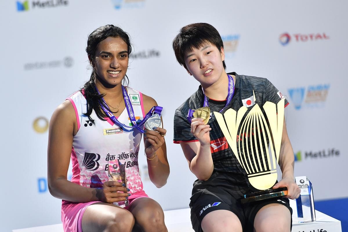 FITTING END Japan's Akane Yamaguchi (right), the Super Series Finals champion, and silver-medallist PV Sindhu with their spoils on Sunday. AFP