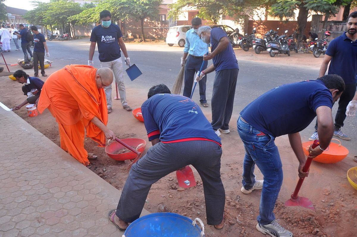 Volunteers clean the area outside Cascia High School in Mangaluru on Sunday.