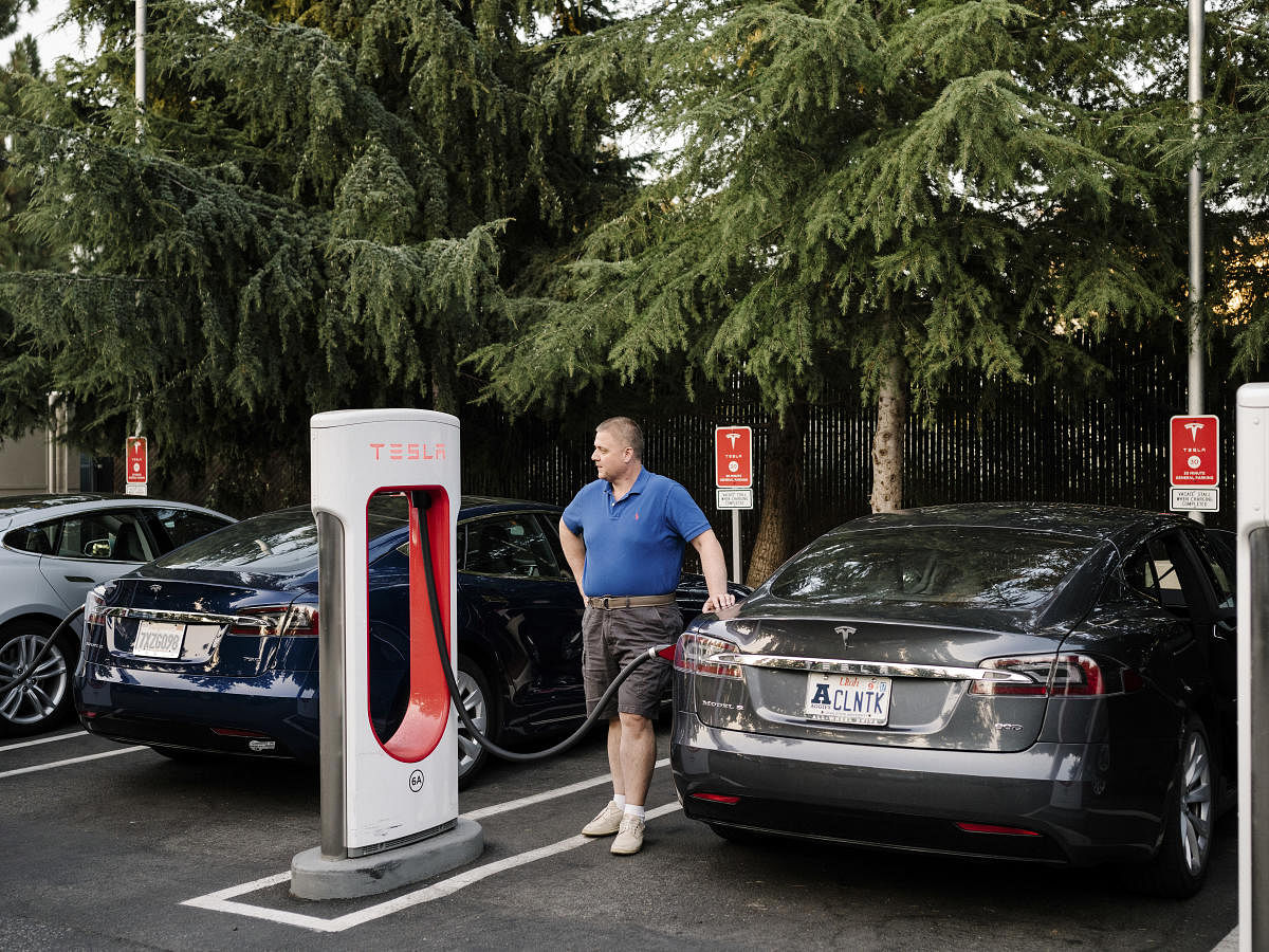 FILE -- Edwin Stafford charges his Tesla at an electric charging station in Mountain View, Calif., Aug. 8, 2017. Prices for lithium-ion batteries are plummeting and technical advances are increasing driving ranges and cutting recharging times: Faster than anyone expected, electric cars are becoming as economical and practical as cars with conventional engines. (Jason Henry/The New York Times)Edwin Stafford charges his Tesla at an electric charging station in Mountain View, Calif., Aug. 8, 2017. Prices for lithium-ion batteries are plummeting and technical advances are increasing driving ranges and cutting recharging times: Faster than anyone expected, electric cars are becoming as economical and practical as cars with conventional engines. NYT