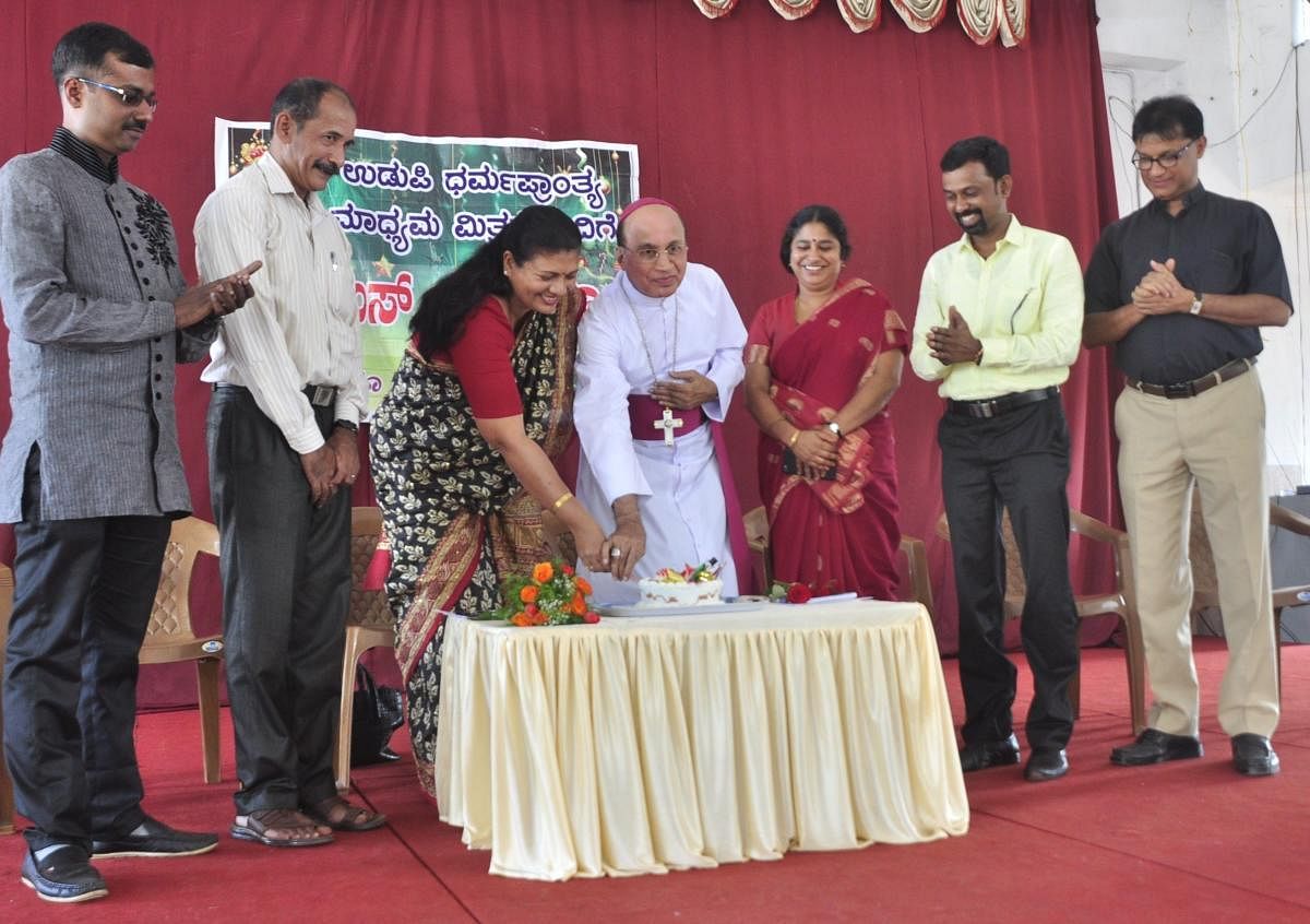 Udupi diocese Bishop Rev Dr Jerald Isaac Lobo and Corporation Bank DGM Delia Pais cut a cake to mark Christmas celebration at Bishop's House in Udupi as District Information Officer Rohini K, Udupi diocese PRO Fr Denis D'Sa and Christian Development Board Member Prashanth Jathanna among others look on.