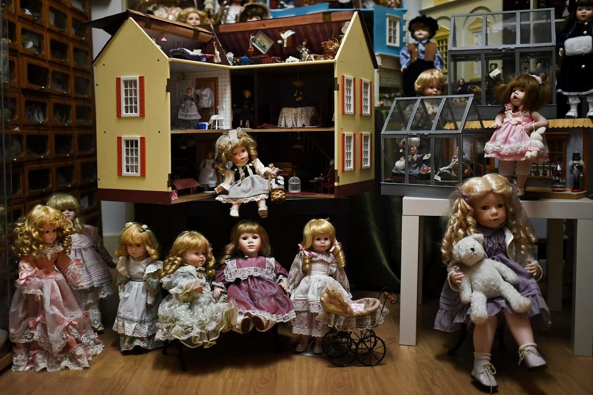 A picture shows dolls and a doll house at the Doll Hospital in Lisbon on December 12, 2017. These delicate toys have been restored or collected with care and affection for five generations, at the