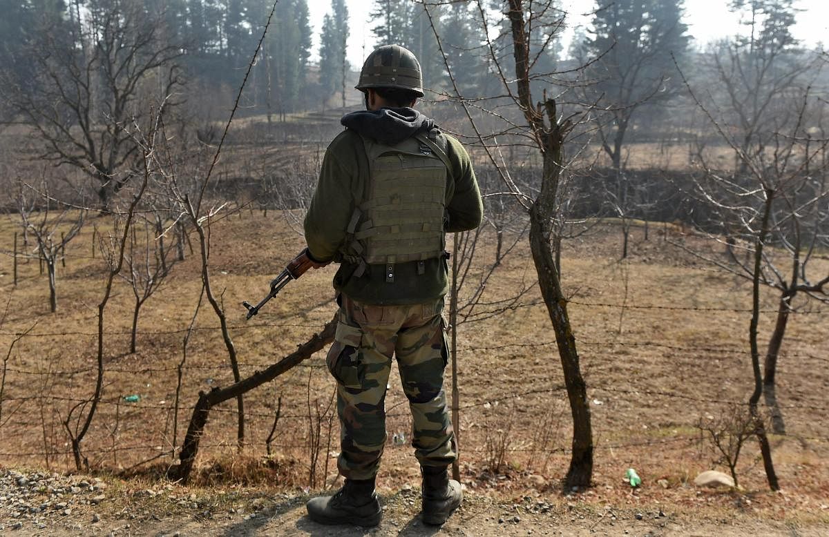 An army soldier stands guard during an encounter with the militants at Futlipora Pakharpora in Budgam district of central Kashmir. PTI