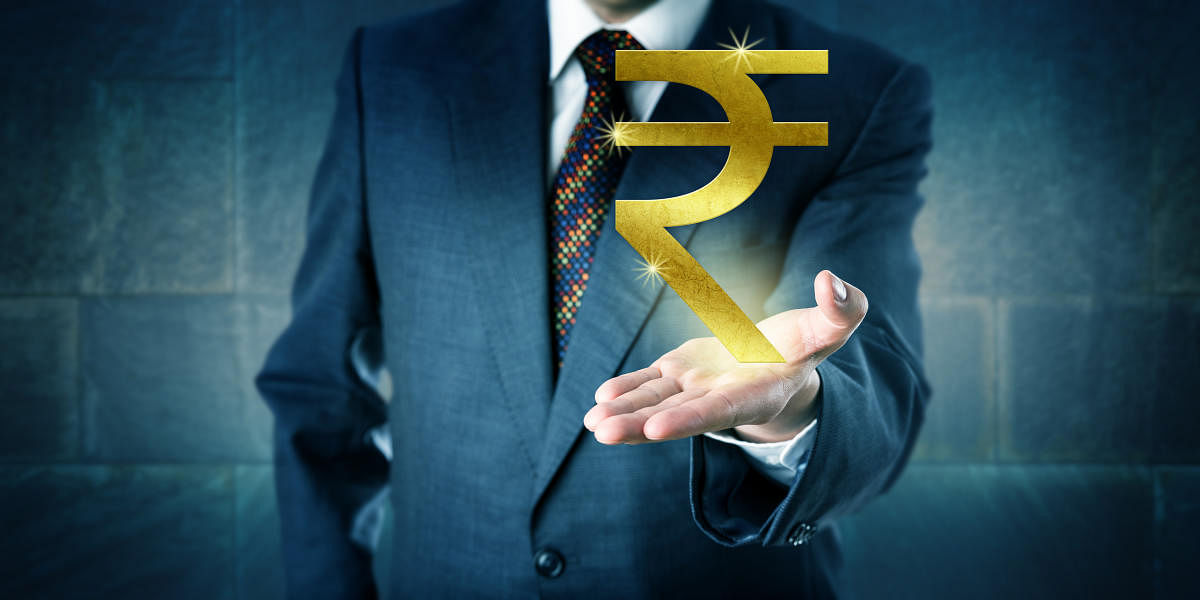 Businessman offering a golden Indian rupee symbol in the open upward facing palm of his left hand. Business metaphor and financial concept for national currency, interbank market and investment.Bad loans