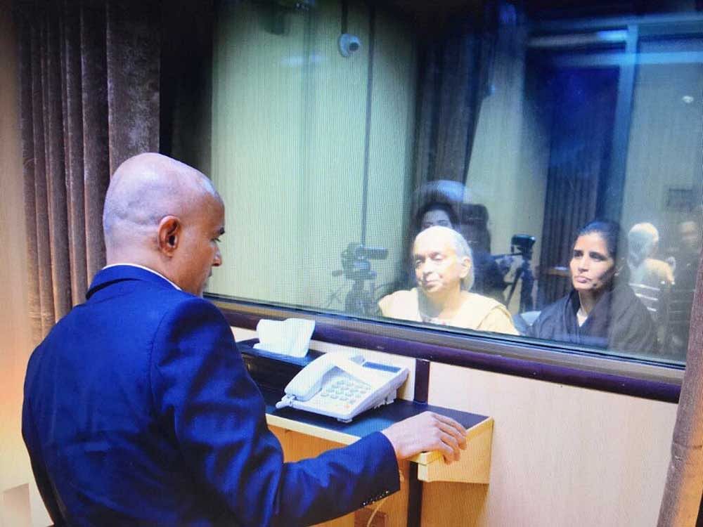 Kulbhushan Jadhav talking with his mother, a pane of glass between them. Twitter photo.