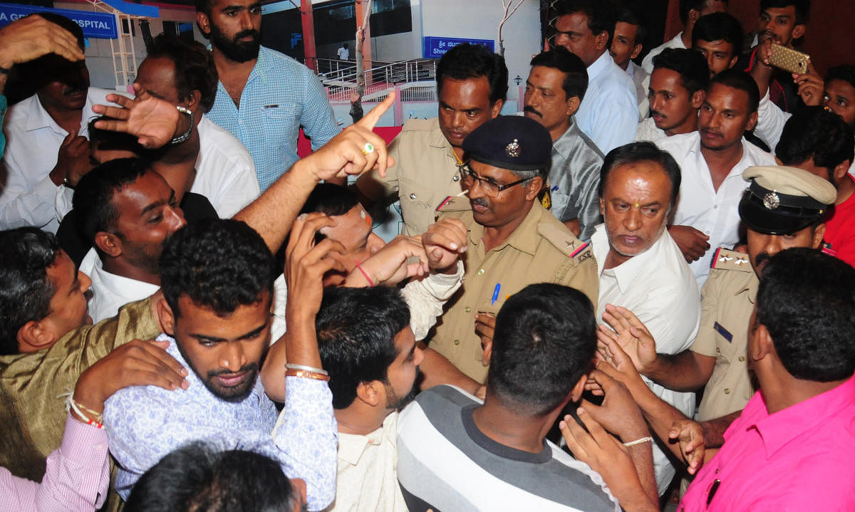 Police personnel intervene to pacify the agitators during the inaugural function of the 'Lingayata Samskruthika Samithi' at Nataraja Sabha Bhavana in Mysuru on Monday.