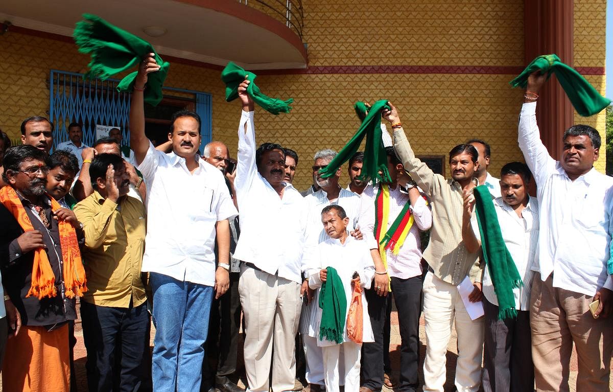 Mahadayi agitators waving green towels in front of circuit house in Hubballi on Tuesday, on the eve of Malaprabha command area bandh.