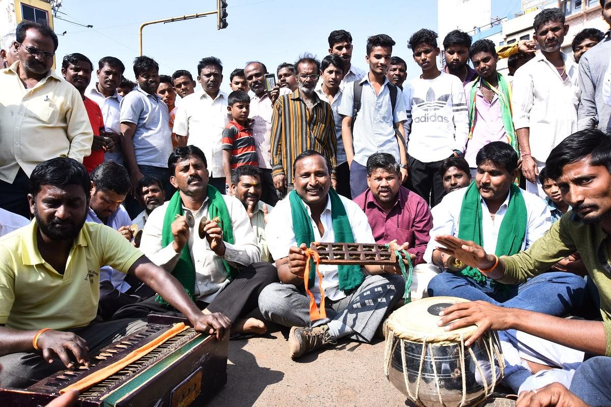 Protesters sing bhajans during their protest on the occasion of bandh, at Chennamma Circle in Hubballi on Wednesday.