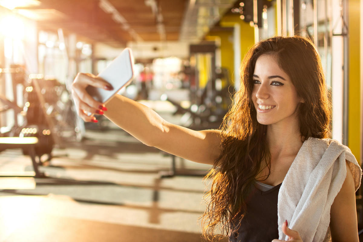 A young woman taking a selfie at the gym.