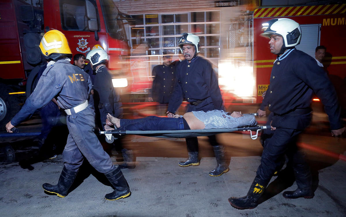 Firefighters carry a victim on a stretcher after a fire broke out at a restaurant in Mumbai on Friday. REUTERS