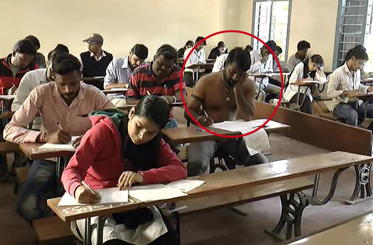 A student writes examination without a shirt at Sarada Vilas College in Mysuru on Friday.