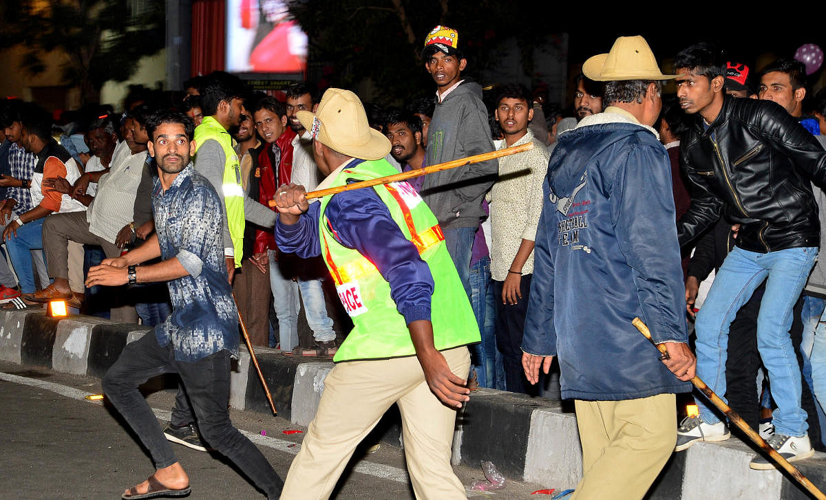 Police cane the crowd on Brigade Road. DH PHOTO/Ranju P