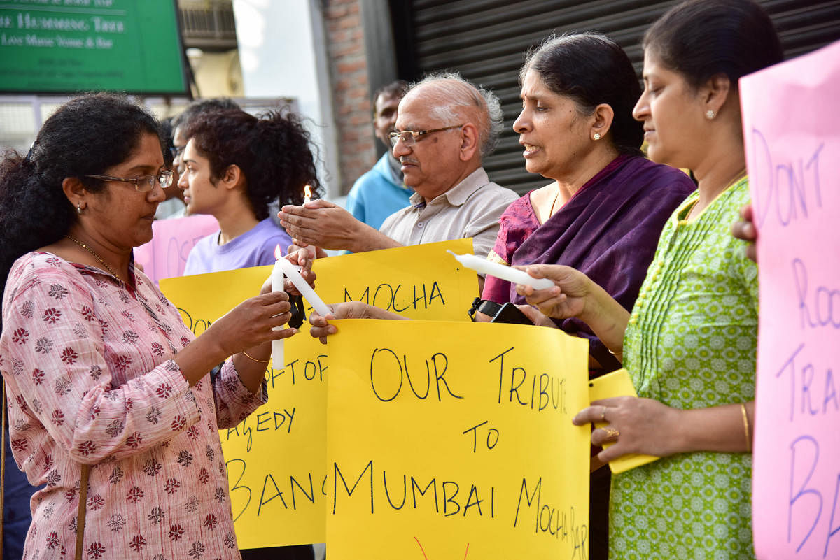 Residents of Indiranagara staging a protest against commercial establishments in by-lanes and nuisance created by Pubs n bars, on the terrace, on 100 feet road and 12th main, in Bengaluru on Sunday. And also Candle light tribute to Mumbai Mocha Bar victims. Photo/ B H Shivakumar