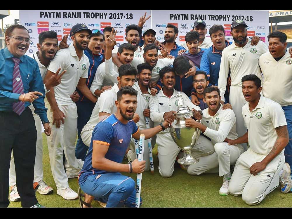 Vidarbha players jubiliate with the trophy after winning the Ranji Trophy final cricket match against Delhi by 9 wickets, in Indore on Monday. PTI Photo