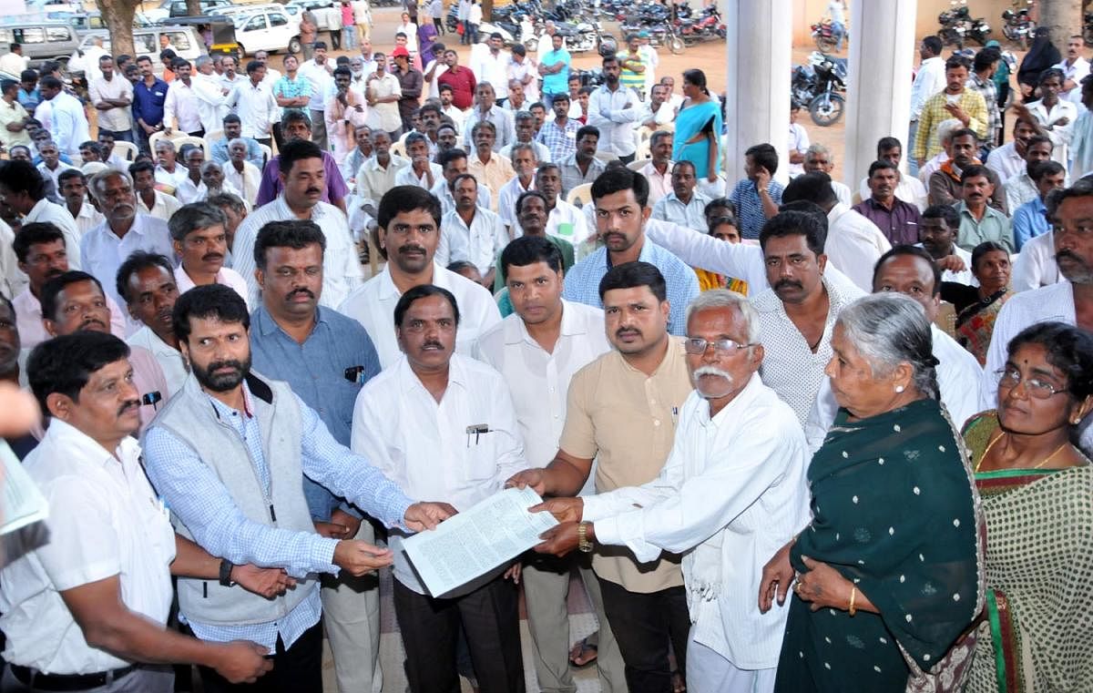 MLA C T Ravi distributes cultivation chits to the people at taluk office premises on Monday.