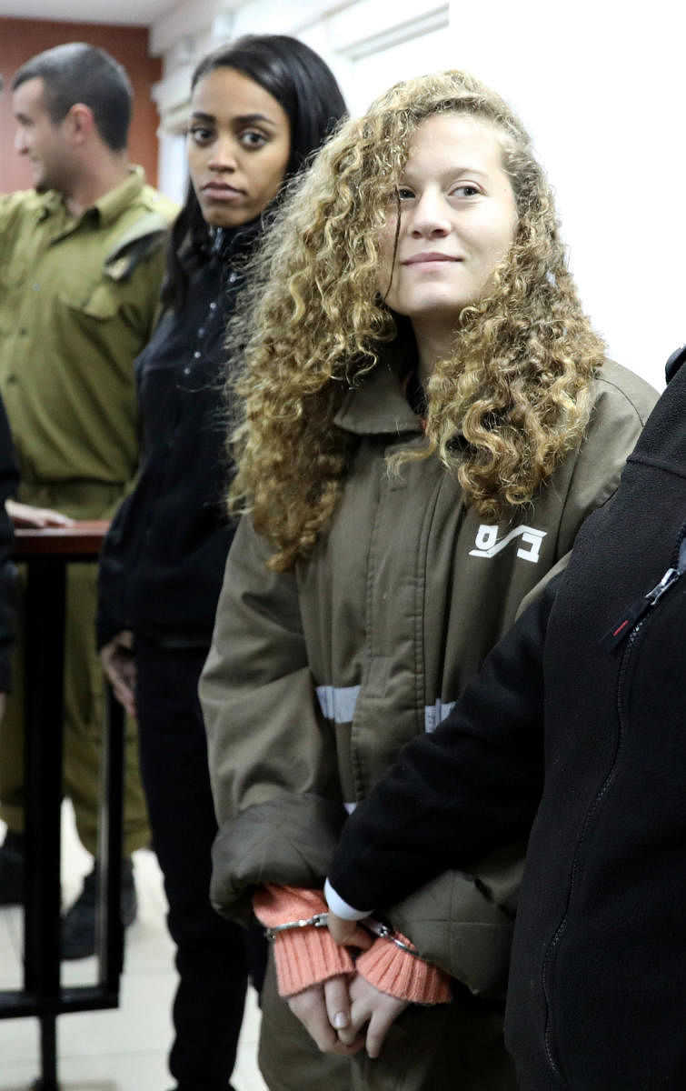 Palestinian teen Ahed Tamimi enters a military courtroom escorted by Israeli Prison Service personnel at Ofer Prison, near the West Bank city of Ramallah, January 1, 2018. REUTERS/Ammar Awad