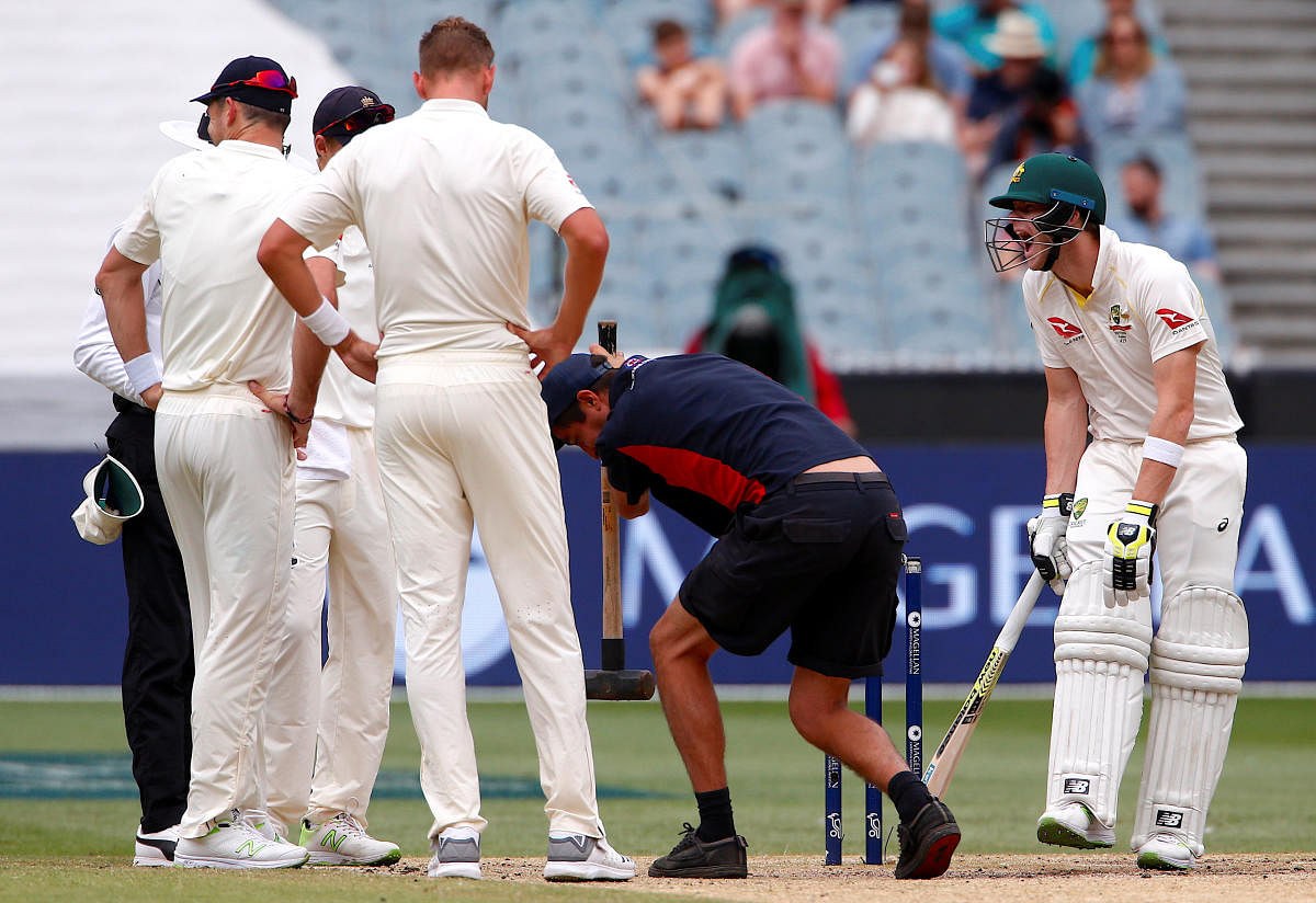 REPAIR NEEDED A groundsman uses a sledgehammer on the Melbourne pitch during the fourth Ashes Test. ICC stated that the pitch didn't provide an even contest with bat and ball. REUTERS