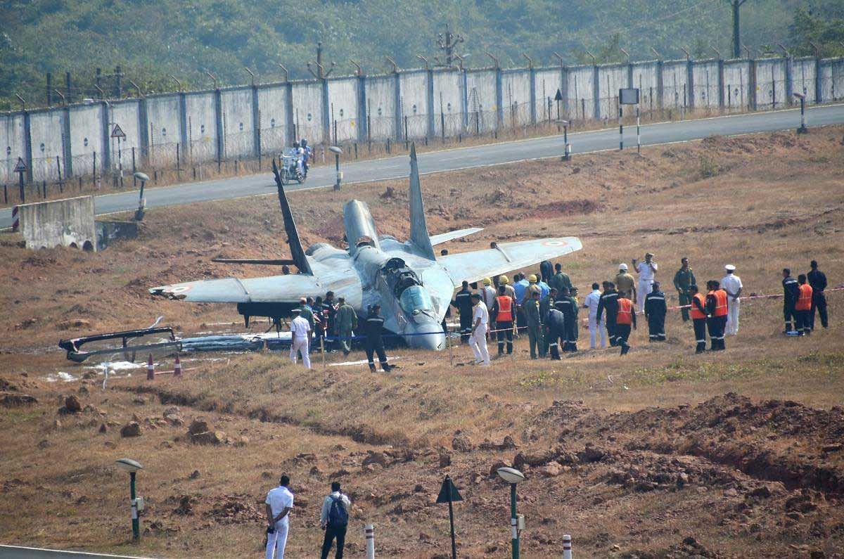 Dabolim: Security personnel standing near the MiG-29 K fighter jet of the navy which overshot the runway and crashed at Dabolim Airport in Goa on Wednesday. PTI Photo