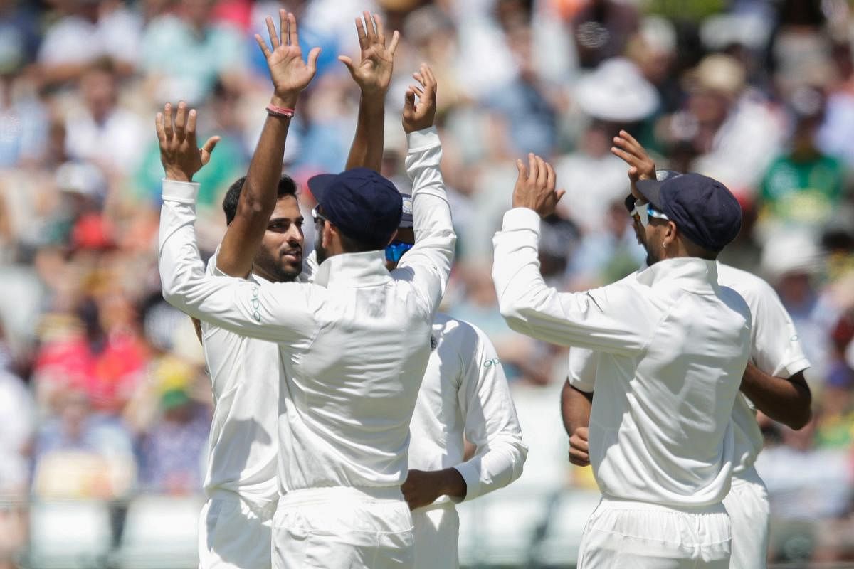 WRECKER-IN-CHIEF India's Bhuvneshwar Kumar (left) celebrates with team-mates the dismissal of South Africa's Hashim Amla on the opening day of the first Test in Cape Town on Friday. AFP