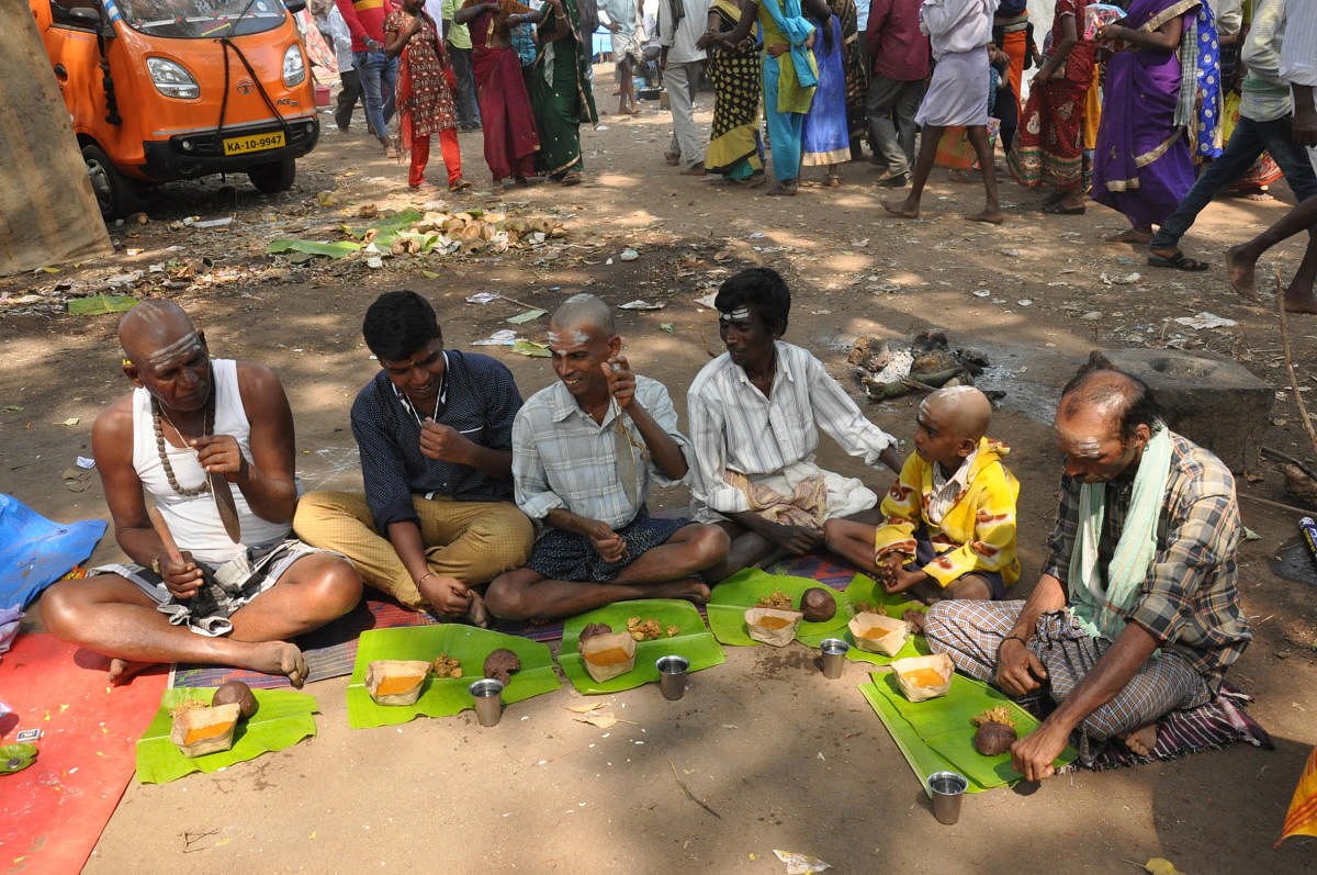 Devotees have food at pankti seva at Chikkallur, Kollegal on Friday.