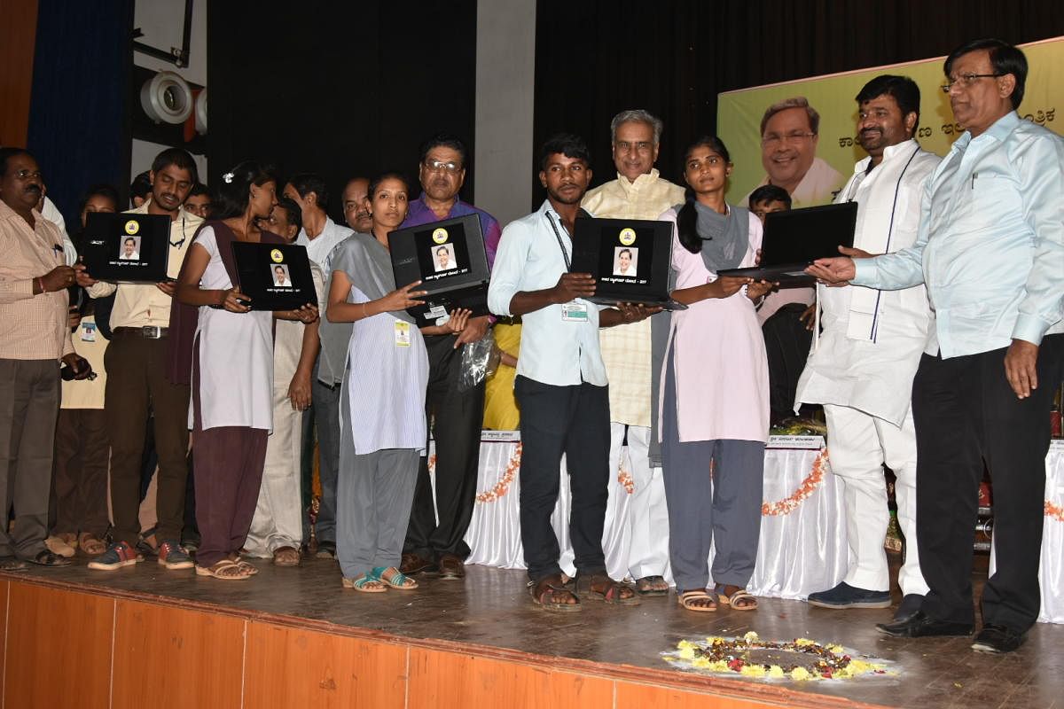 (From right) Higher Education Minister Basavaraj Rayareddi, District In-charge Minister Vinay Kulkarni, and MLC Basavaraj Horatti distribute free laptops to SC/ST students of government colleges, in Hubballi on Friday.