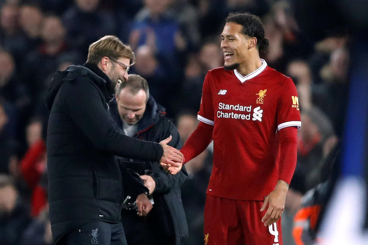 DREAM START Liverpool's Virgil van Dijk celebrates with manager Juergen Klopp after netting the winning goal on his debut game against Everton. REUTERS