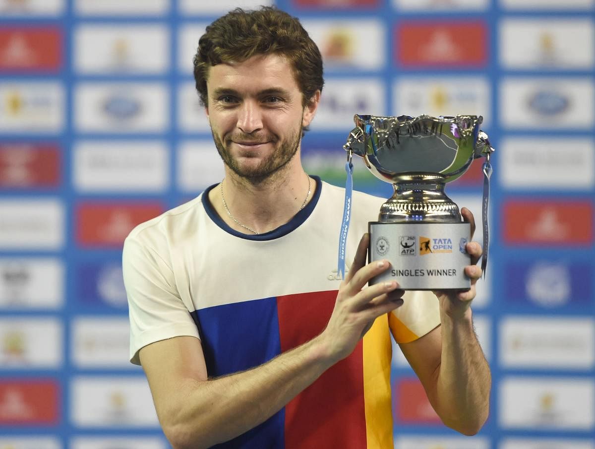 Gilles Simon of France poses with the men's single winners trophy of the of the Tata Open Maharashtra ATP tennis tournament at the Balewadi Stadium in Pune on January 6, 2018. Simon defeated Kevin Anderson of South Africa 7-6 (4), 6-2. / AFP PHOTO / INDRANIL MUKHERJEE