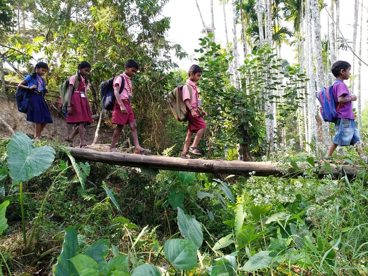 Children cross a footbridge on the way to school.
