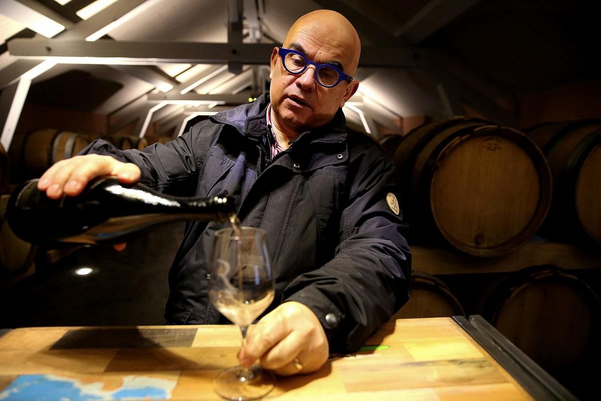 Eric Rodez, organic winemaker in Champagne, pours some of his vintage champagne in a glass in the vat room, of his champagne house in Ambonnay on December 20, 2017. More and more vine growers turn their backs on phytosanitary products, and want to develop organic champagnes in order to reveal the typicality of the terroir. But it's still a marginal movement since only 1.9 % of the vineyard of the appellation is labeled organic. / AFP PHOTO / FRANCOIS NASCIMBENI
