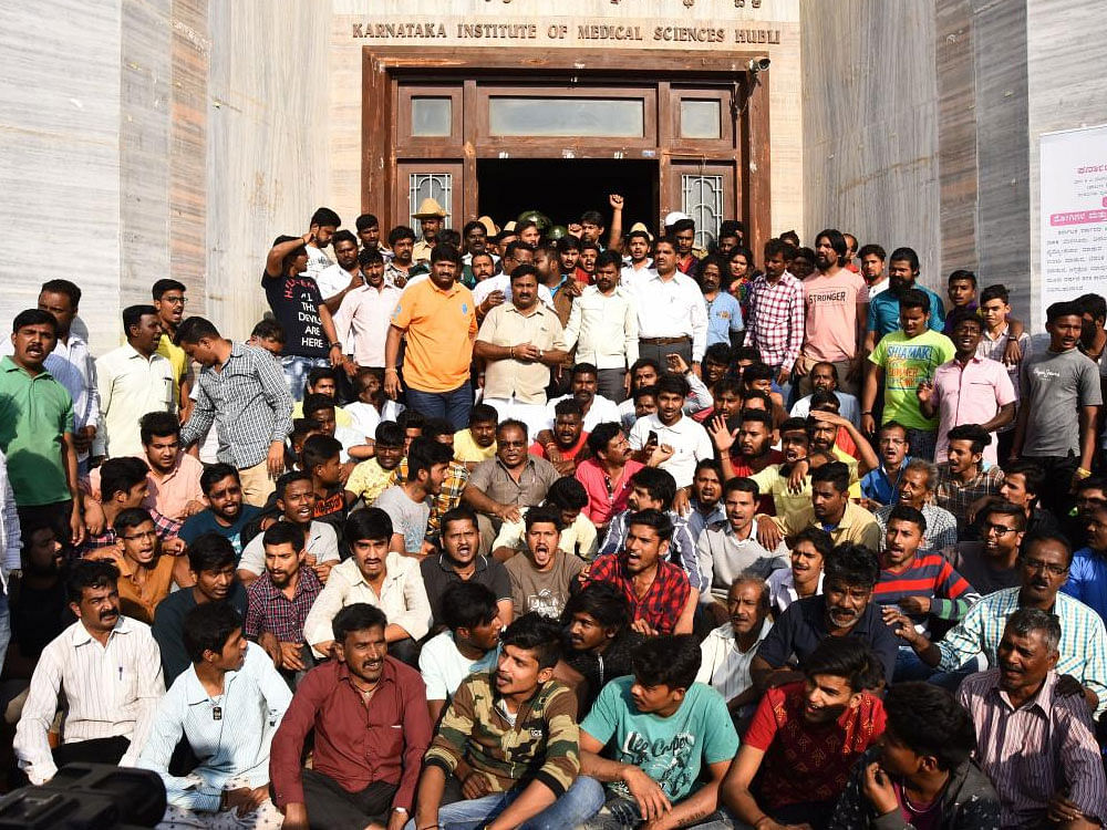 Relatives and friends of accident victim Praveen Mule stage protest in front of the KIMS main building in Hubballi on Monday.