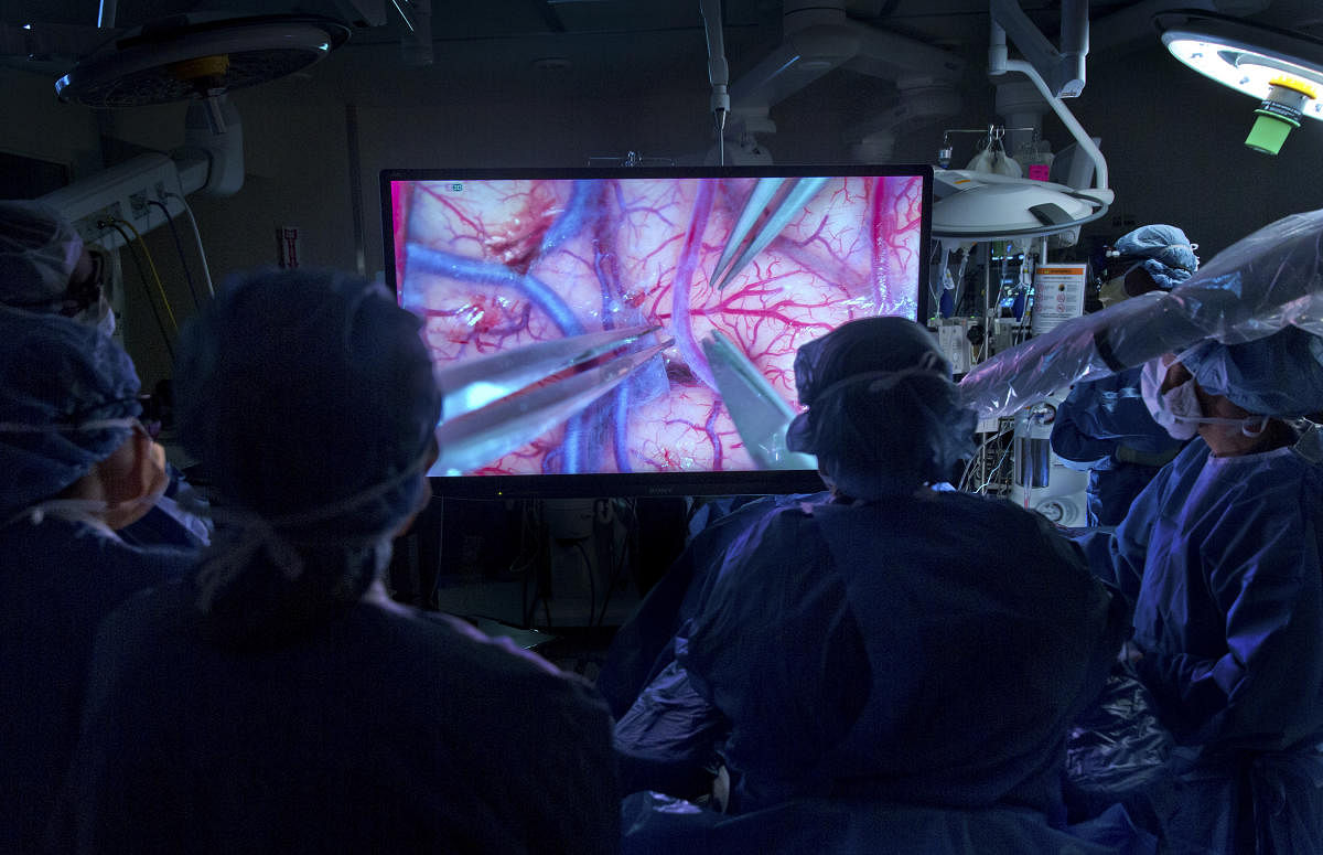 During a brain surgery, a team led by Dr. David Langer uses a videomicroscope, which provides a magnified, high-resolution 3-D image, at Lenox Hill Hospital in New York, Dec. 15, 2017. Surgeons who have tested the technology predict it will change the way many brain and spine operations are performed and taught. The first time I used it," said Dr. Langer., "I told students that this gives them an understanding of why I went into neurosurgery in the first place. (Batrice De Ga/The New York Times)