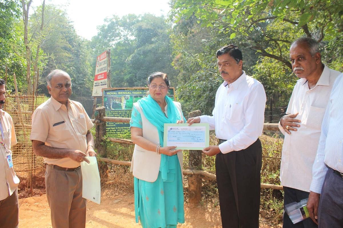 Union Steel Minister Chowdhry Beerendra Singh's spouse and Haryana MLA Premalatha hands over a cheque of Rs 2.50 lakh to Dr Shiavram Karanth Pilikula Biological Park Director Jayaprakash Bhandary, towards the adaption of tigress 'Rani' at Pilikula, by KIOCL.