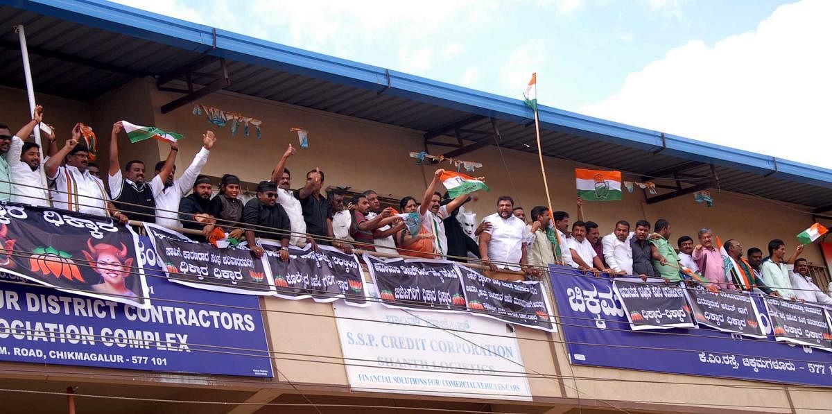 The Congress workers wave flag against the protest staged by the BJP in Chikkamagaluru on Friday.