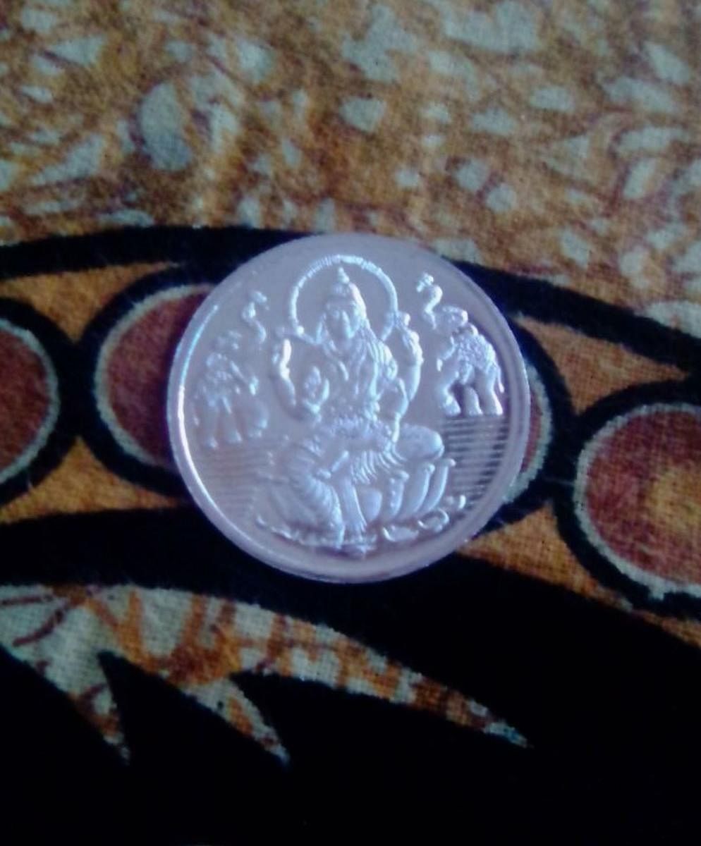 The silver coin that was allegedly distributed by Srirangapatna MLA Rameshbabu Bandisiddegowda on Friday.