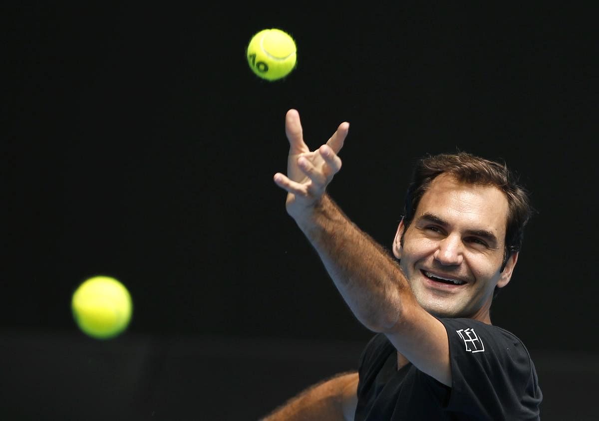 Tennis - Australian Open - Melbourne, Australia, January 14, 2018. Roger Federer of Switzerland laughs as he serves during a practice session before the Australian Open tennis tournament. REUTERS/Toru Hanai