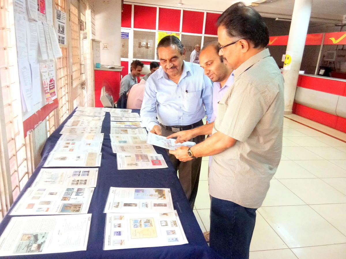 Philatelist K Shridhar explains one of his collections to the visitors during a philately exhibition at the head post office in Pandeshwar on Sunday.