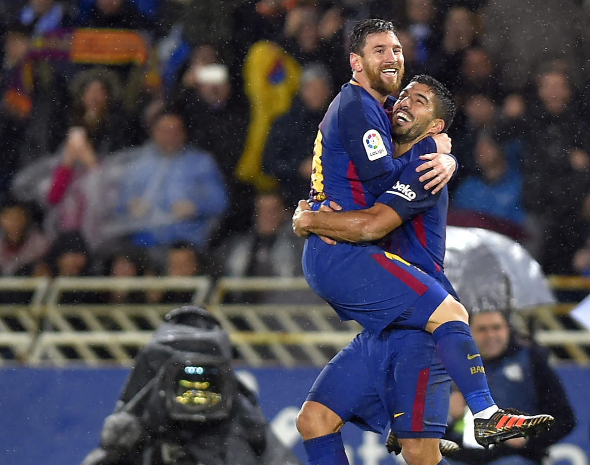 Two to tango: Barcelona's Lionel Messi (left) celebrates with team-mate Luis Suarez after scoring their team's fourth goal against Real Sociedad. AFP