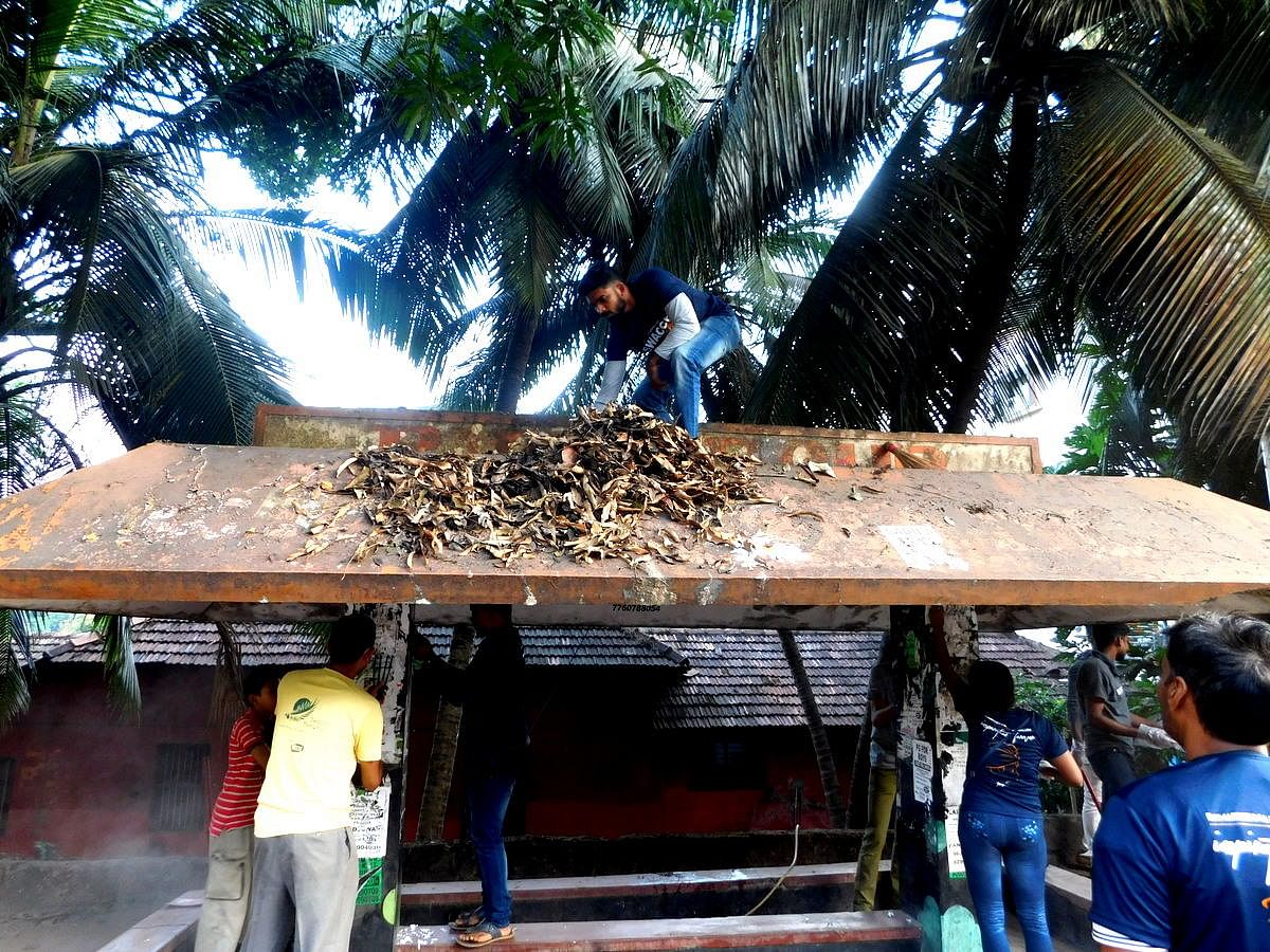 Volunteers cleaning the bus shelter at Kodialbail on Sunday.