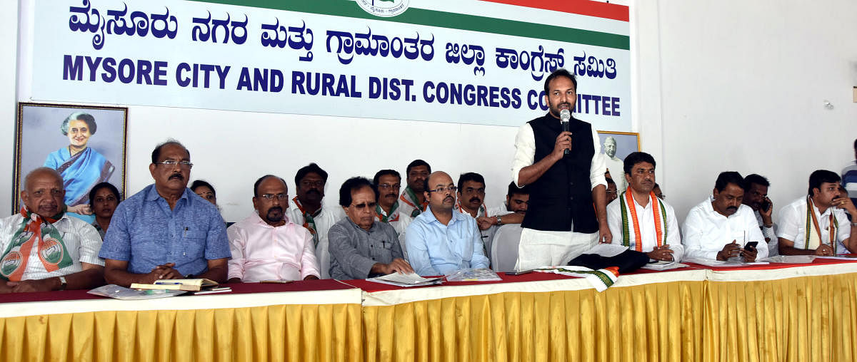 Karnataka Congress in-charge Vishnunadhan addresses the party workers at a meeting in Mysuru on Wednesday. Chairman of Varuna Assembly constituency Housing Programmes Awareness Committee Dr Yatindra Siddaramaiah, former minister B K Chandrashekar are seen.