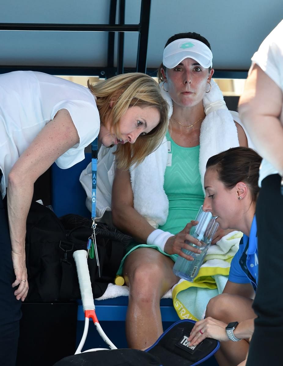 GRUELLING France's Alize Cornet receives medical attention after she slumped to the court due to extreme heat during her third round game against Belgium's Elise Mertens. AFP