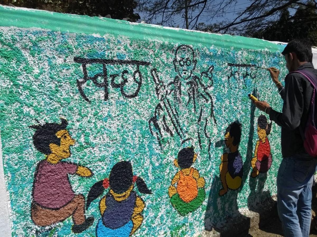 An artist busy painting the wall of Victoria School in Mysuru on Friday.