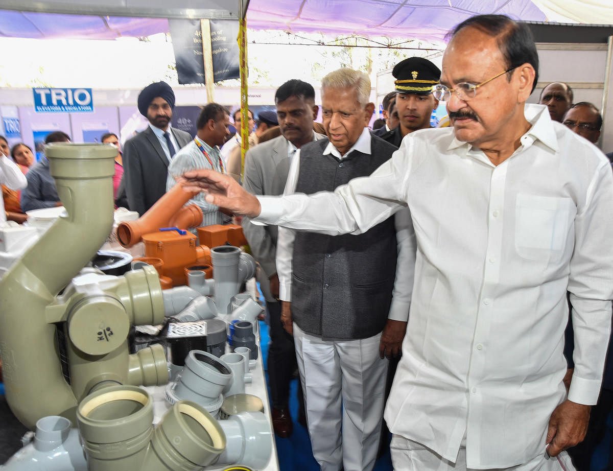 Vice president M Venkaiah Naidu looks at an exhibit atthe All India Builders' Convention on Friday. GovernorVajubhai Vala looks on. DH PHOTO