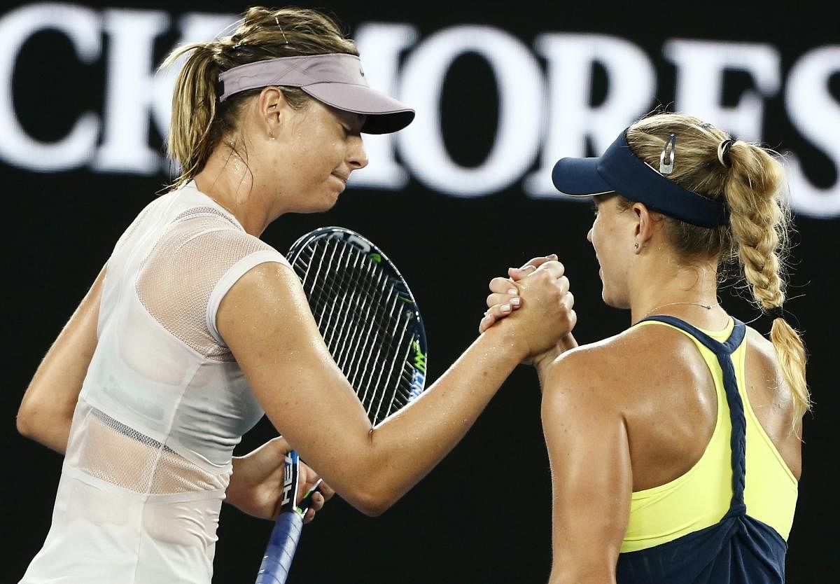 Angelique Kerber of Germany shakes hands with Maria Sharapova of Russia after Kerber won their match. REUTERS/Thomas Peter