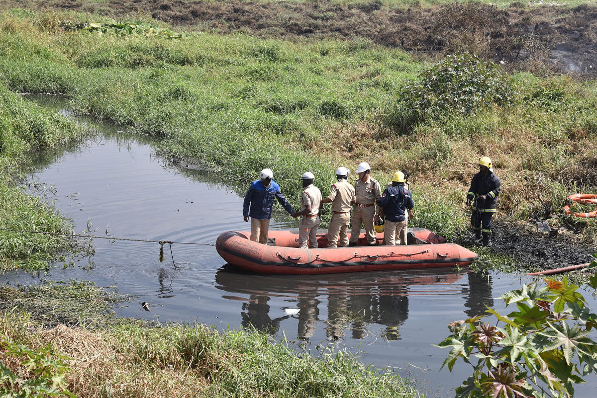 Firemen use a boat to reach the spot of the fire in Bellandur Lake on Saturday. DH Photo