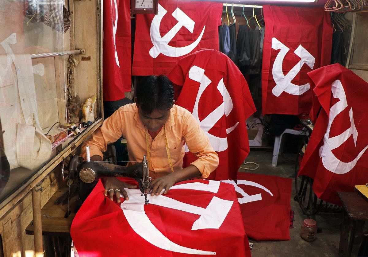 A tailor stitches CPM party flags at a workshop, ahead of Tripura Assembly election, in Agartala. PTI