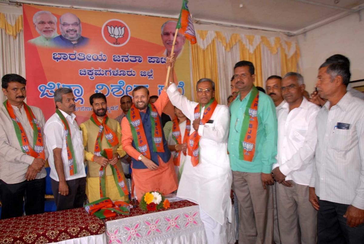 Union Minister Prakash Javadekar who is also BJP's election in-charge for Karnataka assembly polls welcoming Omkarappa and his associates by handing over the party flag in Chikkamagaluru on Monday.