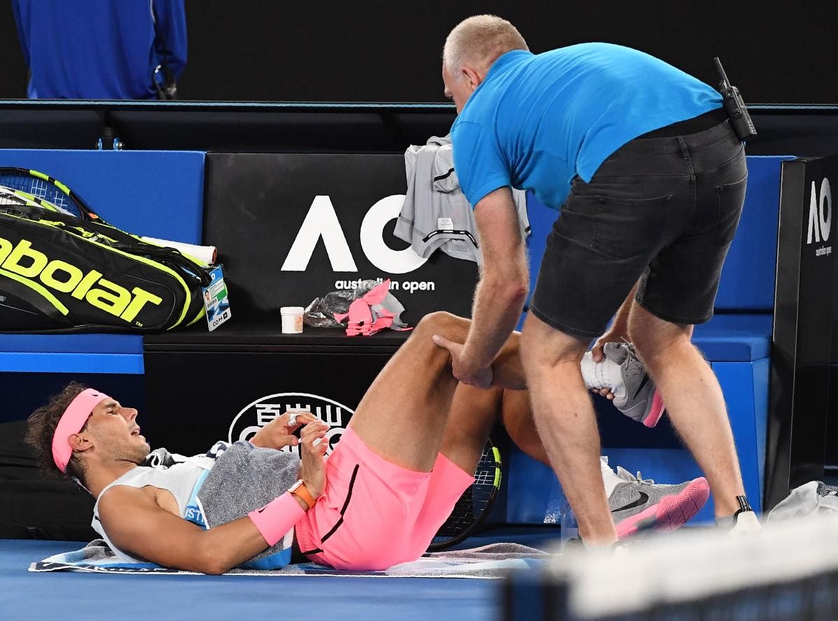 BODY BLOW: Spain's Rafael Nadal receives medical attention during his quarterfinal against Croatia's Marin Cilic on Tuesday. AFP