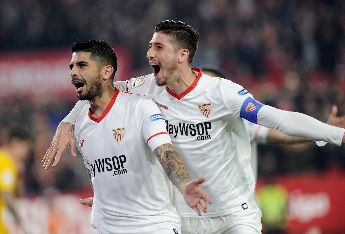 Sevilla's Argentinian midfielder Ever Banega (left) celebrates with Sergio Escudero after scoring against Atletico on Tuesday. AFP