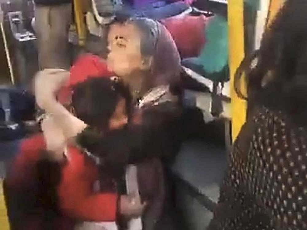 A woman hugs a child crouched on the floor of the GD Goenka World School bus, as a mob protesting against the film 'Padmaavat' threw stones at their bus in Gurugram on Wednesday. PTI Photo