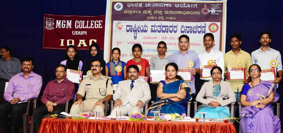 District and Sessions Court Judge Venkatesh Naik, Deputy Commissioner Priyanka Mary Francis and Superintendent of Police Laxman Nimbargi among others pose for a photograph with the 'millennium voters' at the National Voters Day celebrations in Udupi on Thursday.
