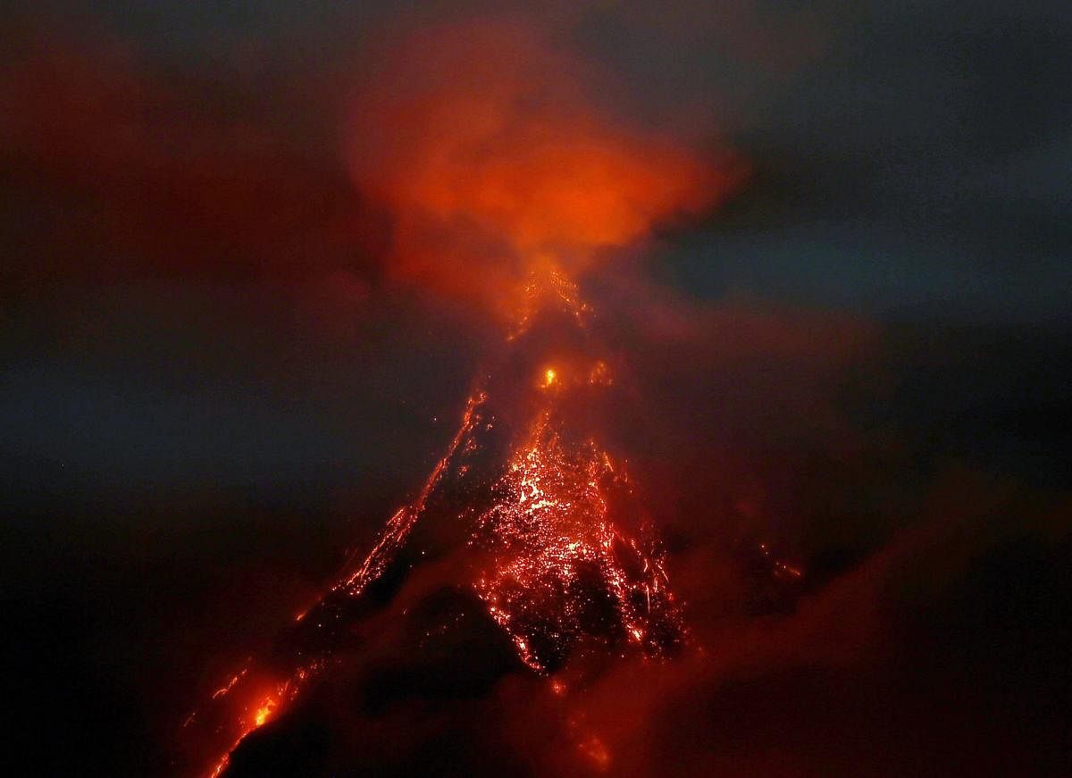 Molten rocks and lava flow down the slopes of Mayon volcano as it erupts anew as seen from Legazpi city, Albay province, southeast of Manila, Philippines Saturday, Jan. 27, 2018. Mayon's lava fountaining has flowed up to more than 3 kilometers (1.86 miles) from the crater in a dazzling but increasingly dangerous eruption.